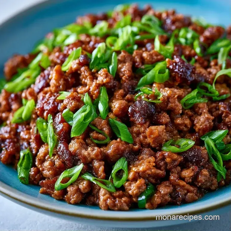 Saut&eacute;ed crumbled beef and sliced scallions served in a shallow ceramic bowl with a sprinkle of toasted sesame seeds.
